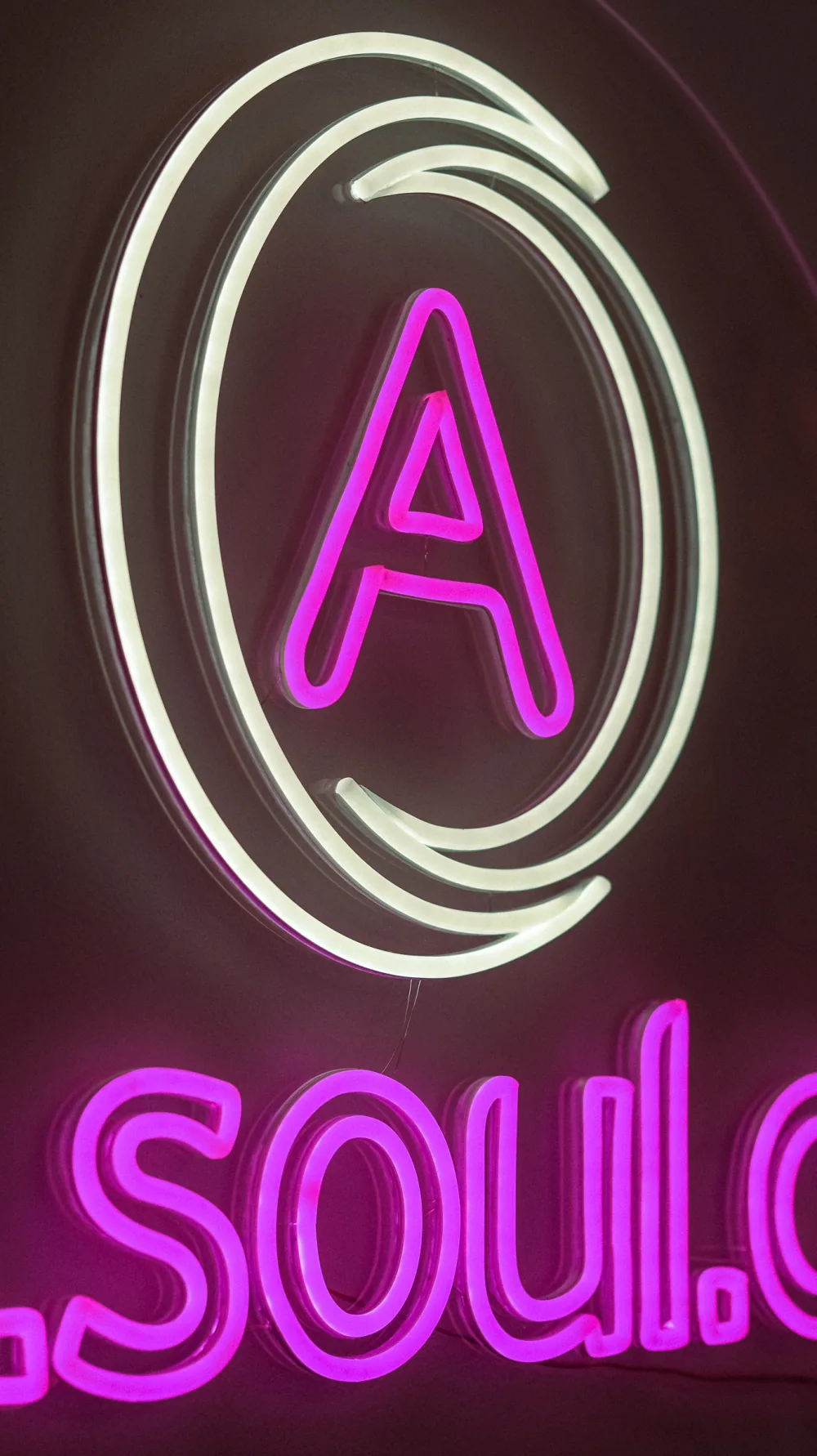 Růžový neonový symbol ALI.SOUL v detailu