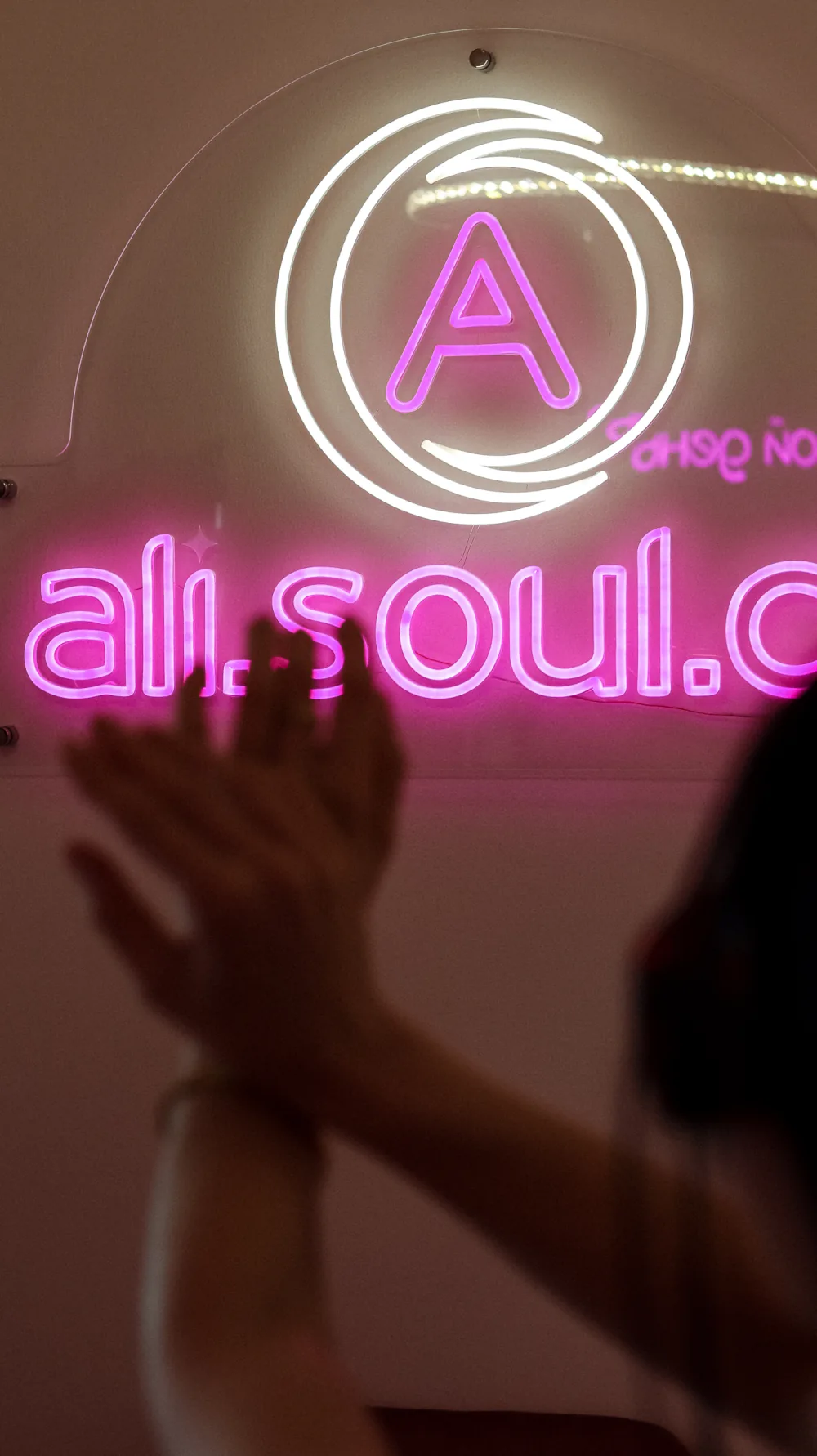Neonové logo ALI.SOUL zachycené v zrcadle